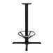A Lancaster Table & Seating black cast iron bar height table base with a round metal ring.