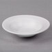 A Libbey Lunar Bright white porcelain bowl on a gray surface.