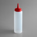 A white plastic squeeze bottle with a red tip.