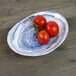 An Elite Global Solutions oval melamine plate with tomatoes on it.