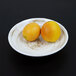 An Elite Global Solutions Van Gogh taupe melamine bowl filled with two oranges.