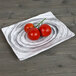 A Elite Global Solutions Van Gogh black rectangular melamine plate with tomatoes on it.