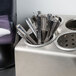 A Steril-Sil stainless steel countertop flatware organizer holding spoons.