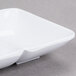 A white square GET Water Lily melamine sauce dish with two sections.