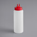 A white plastic Vollrath Twin Tip squeeze bottle with a red lid.