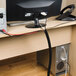 A white rectangular D-Line cable tidy tube with a black border on a desk.