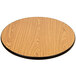 A Lancaster Table & Seating round wooden table top with walnut finish on a table with a cross cast iron base.