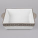 A white square Tuxton casserole dish with a gray and brown stone band.