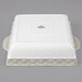 A white square Tuxton casserole dish with a square design on the lid.