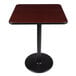 A Lancaster Table & Seating bar height table with a black base and reversible cherry/black top on a round cast iron base plate.