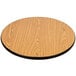 A Lancaster Table & Seating bar height table with a round wooden table top with a black edge on a round cast iron base.