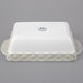 A white rectangular Tuxton casserole dish with a white lid and a truffle band.