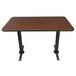 A brown rectangular Lancaster Table & Seating table with black cast iron base plates.