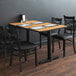 A Lancaster Table & Seating table with a reversible walnut and oak table top on a wood floor.