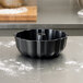 A black Chicago Metallic fluted bundt cake pan on a counter.