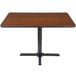 A Lancaster Table & Seating table with a black metal base and reversible walnut/oak top.