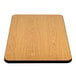 A close-up of a Lancaster Table & Seating rectangular table top with a reversible wood surface.
