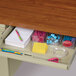 A Hirsh Industries right corner pedestal desk with a drawer and stationery and pens inside.