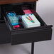 A drawer with stationery and pens including a pencil holder on a Hirsh Industries single pedestal desk.