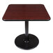 A Lancaster Table & Seating square table with a black base and a reversible cherry/black top.