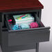 A drawer with a file and a pen holder in a Hirsh Industries charcoal and mahogany single pedestal desk.