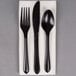 A white linen-like napkin with a pre-rolled black heavy weight plastic cutlery set.