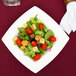 A salad with tomatoes, lettuce, and croutons in a Bone White square porcelain bowl.