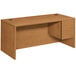 A brown wooden HON 10500 Series pedestal desk with a drawer.