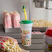 A 16 oz. "Fun at the Fair" souvenir cup with a green lid and straw holding popcorn.
