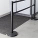 A Lancaster Table & Seating black stanchion with dual black retractable belts.