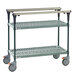 A green and grey Metro PrepMate MultiStation cart with two metal shelves on wheels.