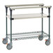 A Metro stainless steel cart with two shelves and wheels.