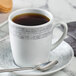 A Schonwald structure grey porcelain tall cup with a handle of coffee on a saucer.