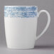 A white porcelain mug with a blue and white structure and handle.
