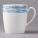 A white porcelain tall cup with a blue surface and handle.
