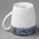 A white Schonwald stone porcelain tall cup with a black speckled design and handle.