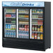 A Turbo Air black refrigerated glass door merchandiser with drinks inside.