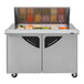 A Turbo Air stainless steel refrigerated sandwich prep table with glass doors filled with food containers.