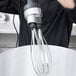 A person using a Waring whisk attachment to mix something.