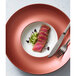 A Villeroy & Boch Copper Glow deep porcelain plate with food on it, with a fork and knife.
