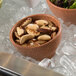 A G.E.T. Enterprises Bugambilia terracotta bowl filled with ice and nuts on a counter.