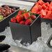 A black G.E.T. Enterprises Bugambilia square salad bowl filled with strawberries on ice.