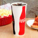 A Solo poly paper cold cup with a Coca Cola logo.