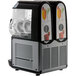 A black and white Vollrath frozen beverage machine with two drinks on it.
