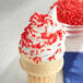 An ice cream cone with Red Sprinkles.