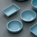 A group of blue Thunder Group Blue Jade melamine bowls on a gray surface.