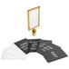 A gold Lancaster Table & Seating stanchion sign frame with black and white signs inside.