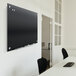 A black Quartet Infinity glass markerboard on a white wall.