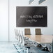 A Quartet frameless black glass markerboard with white text that says "marketing webinar" on it.