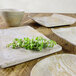 A table with a white Elite Global Solutions Santiago melamine bowl filled with food and a plant on a wooden surface.